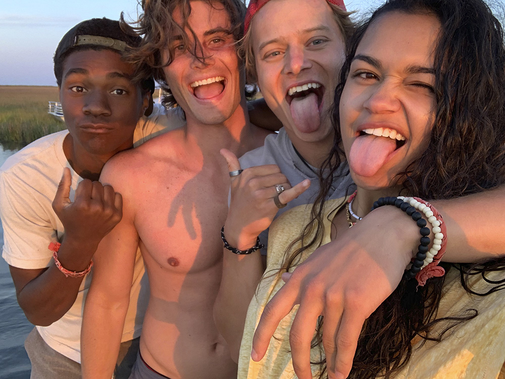 Chase Stokes, Jonathan Daviss, Madison Bailey e Rudy Pankow posam para selfie na praia