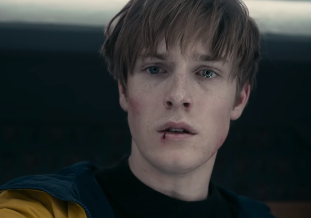 Trilogia Dark, imagem de jonas com a boca machucada e usando o casaco amarelo.