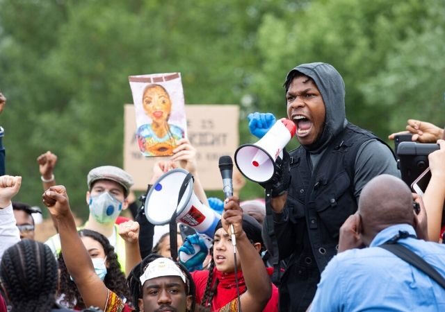 John Boyega discursa em mega fone durante manifestação