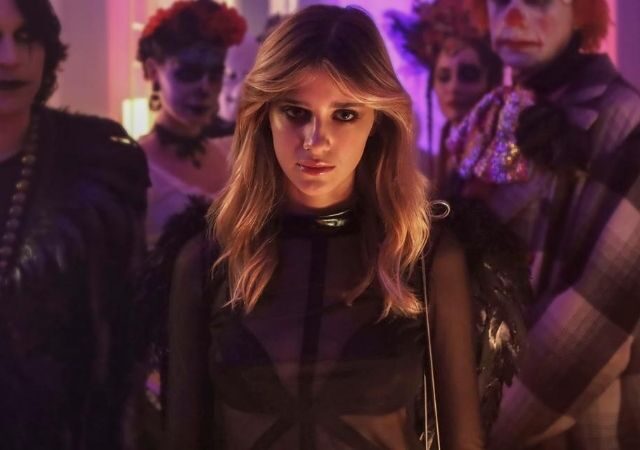 Protagonista da série Baby, Chiara, veste blusa preta transparente com e olha para a câmera