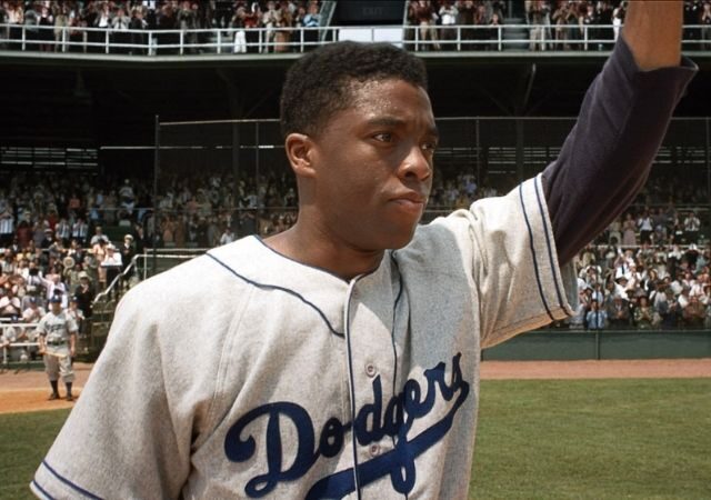 Protagonista de 42 - A História de Uma Lenda veste uniforme de baseball e acena