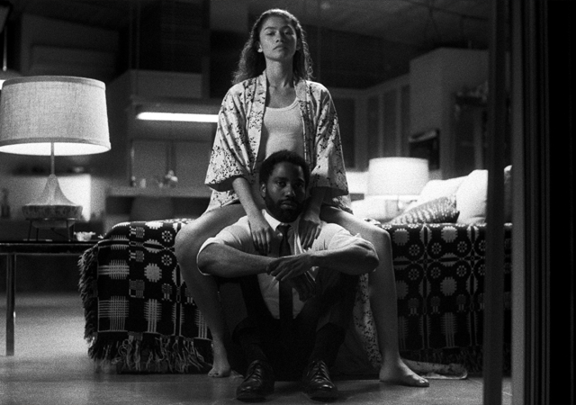 Imagem promocional de Malcolm & Marie, com uma mulher sentada na cama e um homem sentado no chão.