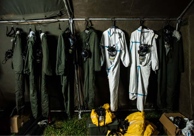 Macacões e máscaras de segurança pendurados em um armário